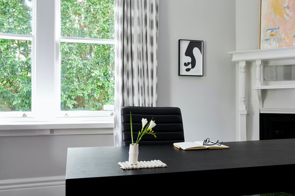 Melbourne based Sarah Hudson's Bamboo #1 sits on a desk with flowers. Melbourne artist Elena Strohfeldt's In the Shadows is on the wall. Affordable Australian art